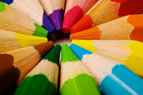 Douze crayons de couleur se trouvent en cercle, se touchant les doigts