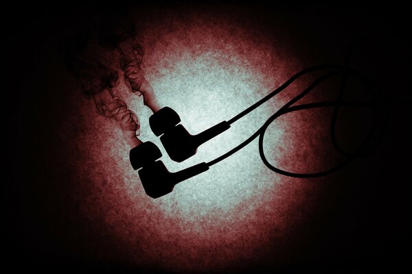 Headphones releasing smoke on a black background