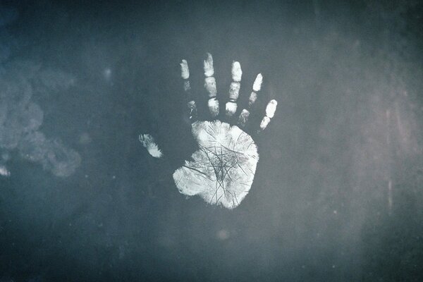 The imprint of a six-fingered palm on the glass