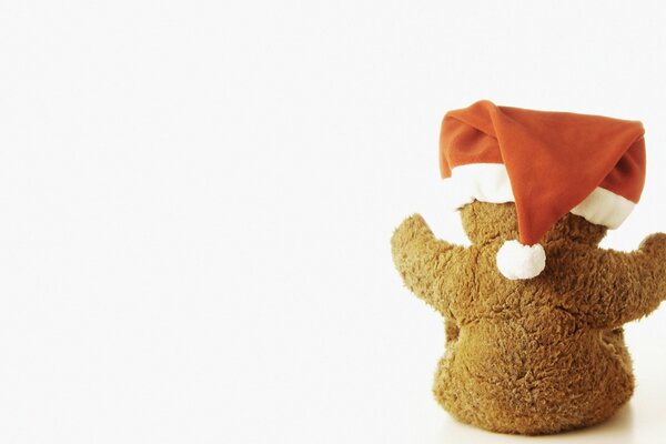 Festive teddy bear in a hat on a light background