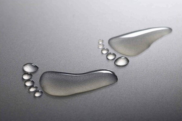 Water drops in the form of a footprint on a gray background