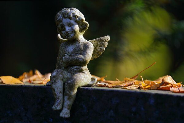 Sculpture of an angel among autumn leaves