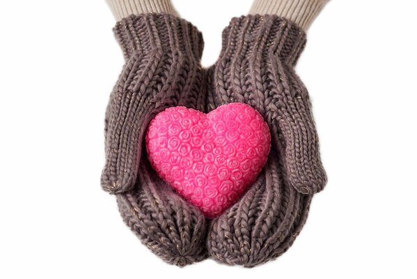 Pink heart on knitted winter mittens