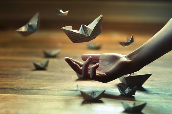 Ręka z papierowymi łodziami origami