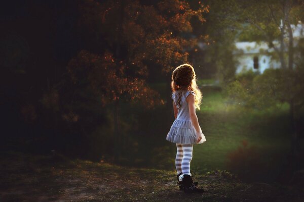 Mała dziewczynka na tle natury patrząca w dal
