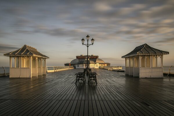 Wet pier after rain on the background of a gorgeous sky