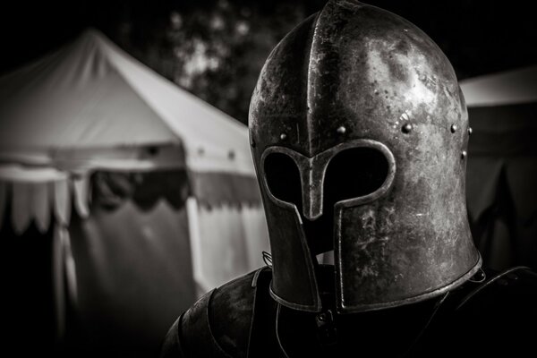 Knight in armor in the tent camp dawn sun