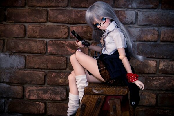 Девочка-кукла с телефоном в руке и очках