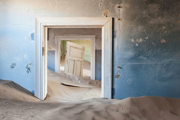 Sand dunes in a room with a door and two doorways