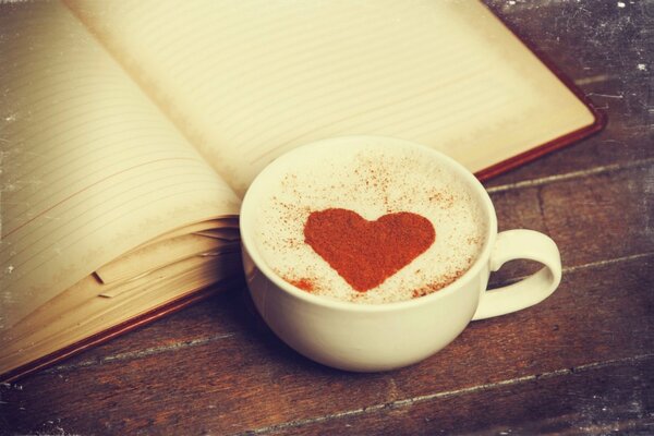 Чашка кофе с рисунком сердца и дневником