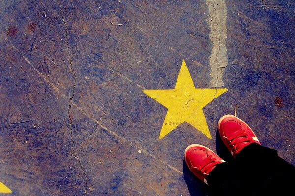 Textura. Zapatillas rojas y una estrella. Dibujo en el asfalto