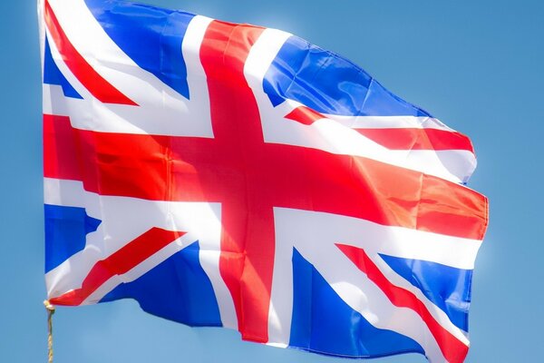 The flag of Great Britain flutters in the wind in the light of day