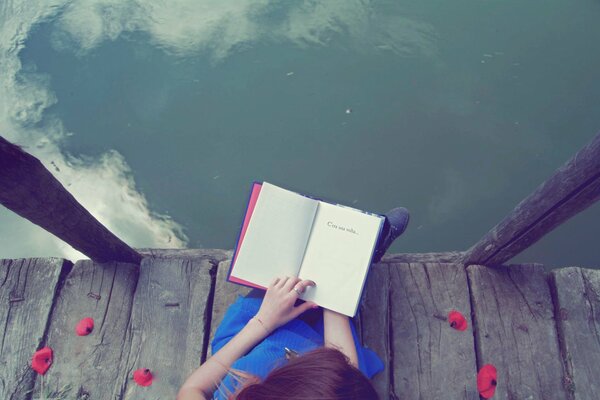 Ragazza in abito blu che legge un libro