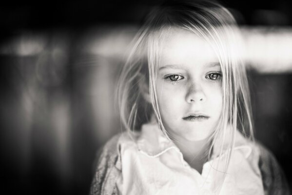Photo en noir et blanc d une fille. Regard triste vers le bas