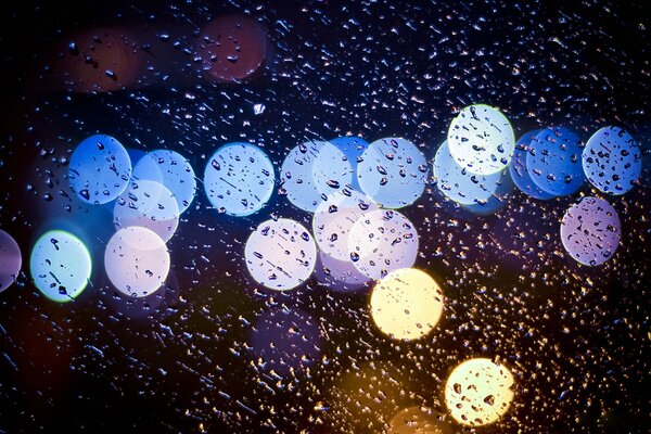 Luci notturne attraverso le gocce di pioggia