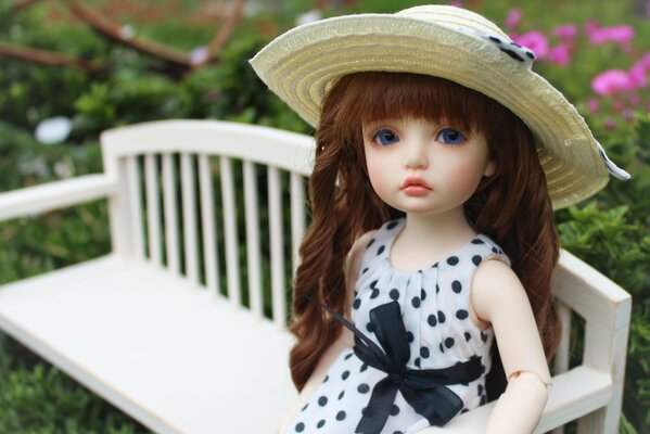 The doll is sitting on a bench