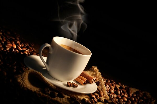 Une tasse de café avec un bâton de cannelle du sac cette saveur est tout sur l épaule