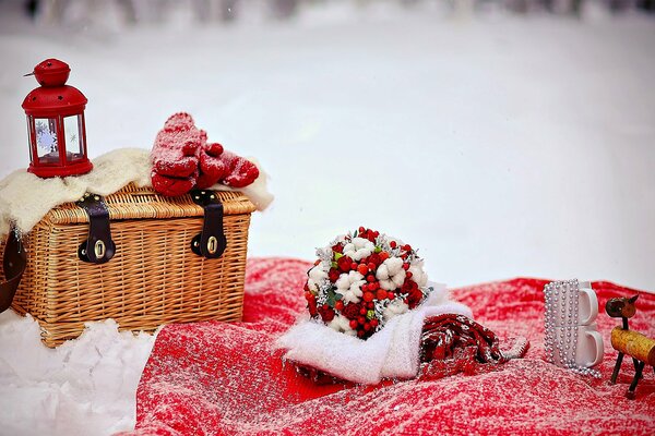 Liebe. hochzeit im Winter. brautstrauß mit roter Eberesche. rote Taschenlampe und Handschuhe auf einem Weidenkorb