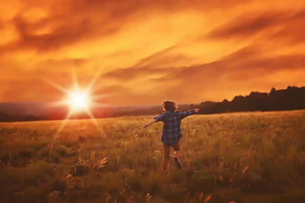 Ein Junge läuft in der Sonne über das Feld