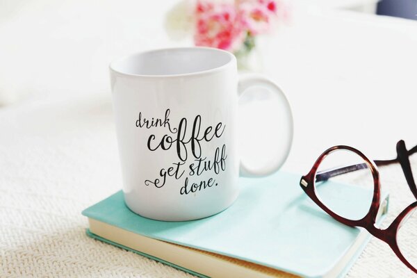 Taza de café con ramo de flores y gafas