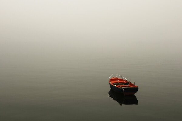 Paysage apaisant: un bateau solitaire dans la brume matinale