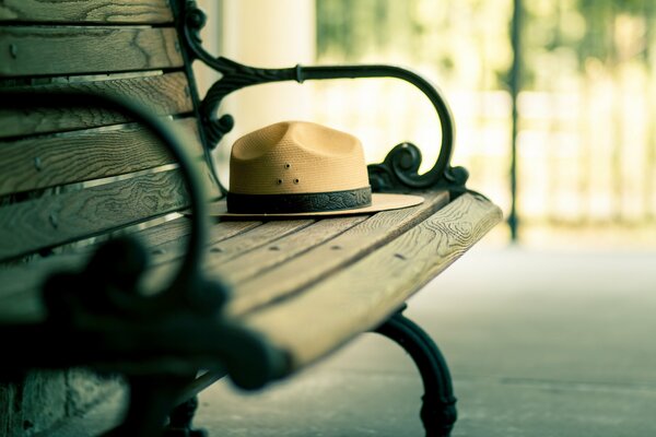 A hat with a brim forgotten on a bench