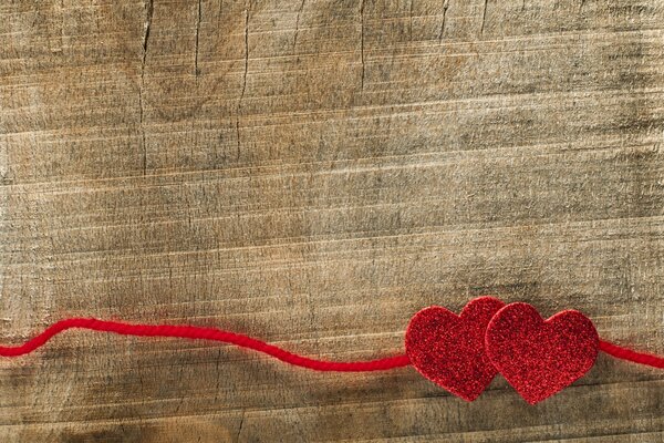 Red hearts with red thread on a tree background
