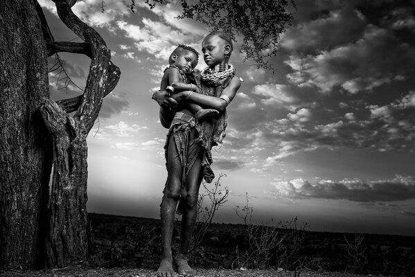 Madre africana con reyenka accanto all albero