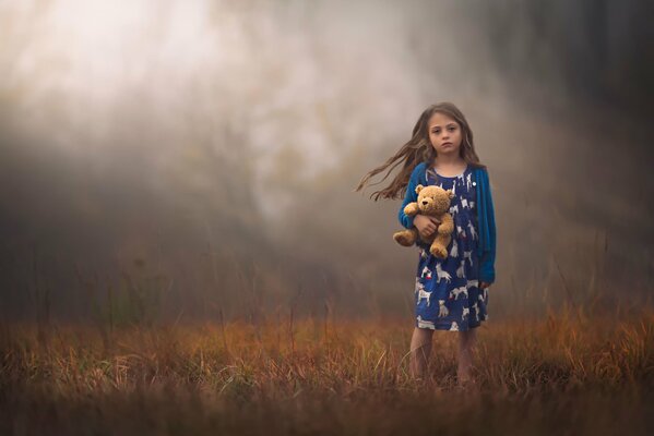 Una niña con un oso de peluche en el fondo de un proto