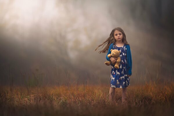 Fille avec un ours en peluche sur fond de germination