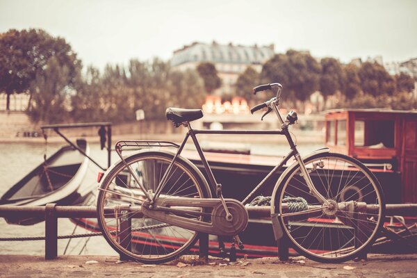 Czarny rower pozostawiony przy molo, sepia