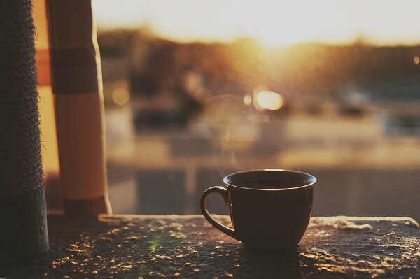 Tasse auf dem Hintergrund der aufgehenden Sonne