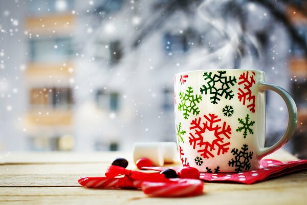 Taza festiva y dulces en la mesa