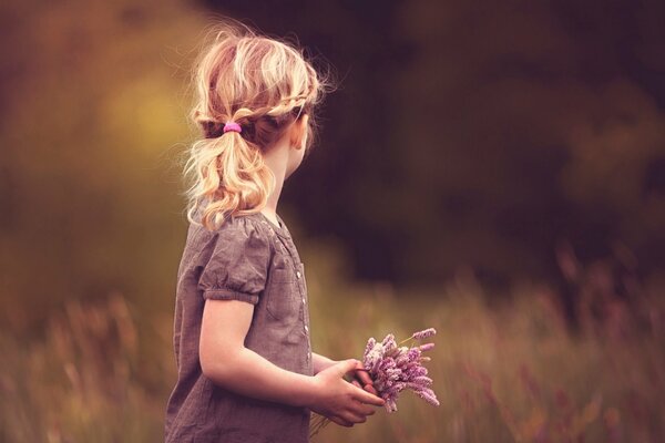 Foto de una niña con flores en medio del bosque