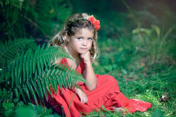 Mirada de niña sentada y flores en la naturaleza