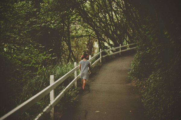 Девочка гуляет по лесной дорожке