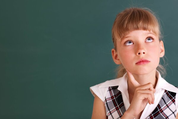 Colegiala pensativa en una camisa a cuadros