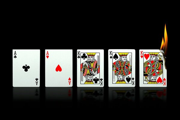 Quattro carte da gioco uno dei quali è illuminato su sfondo nero