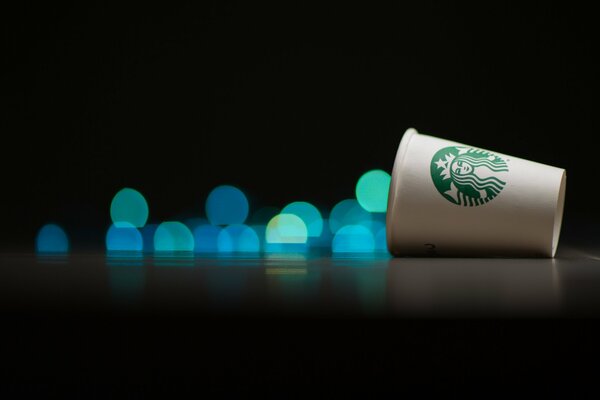 Un verre de Starbucks se trouve sur un fond de reflets