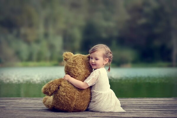 Ragazza con un orso sulla riva del Lago