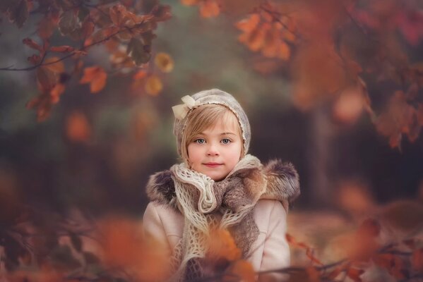 Retrato de otoño de una niña con un sombrero y una bufanda retro