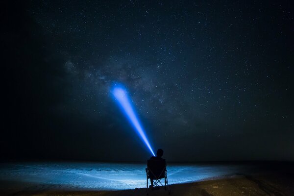 L uomo brilla una lanterna sul cielo stellato