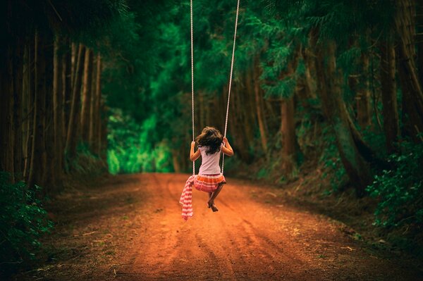 Swing in the forest with a girl riding