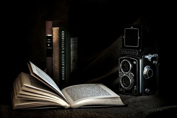 Libro aperto sullo sfondo della fotocamera e libri