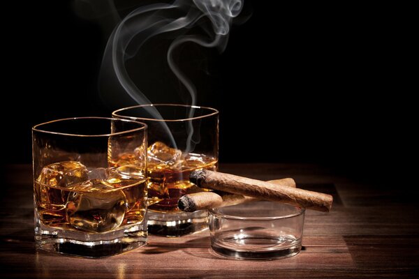 Verre de whisky avec de la glace et des cigares