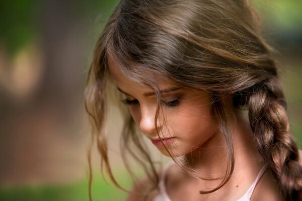 Belle fille avec une tresse baissa la tête vers le bas