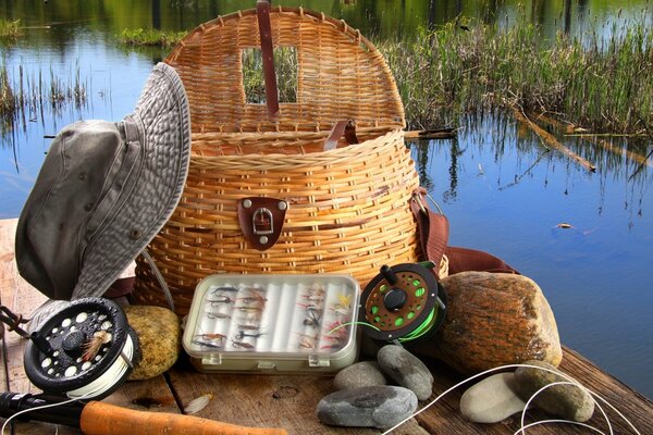 Fishing gear on the bridge. Hat. Pond. Wicker Basket