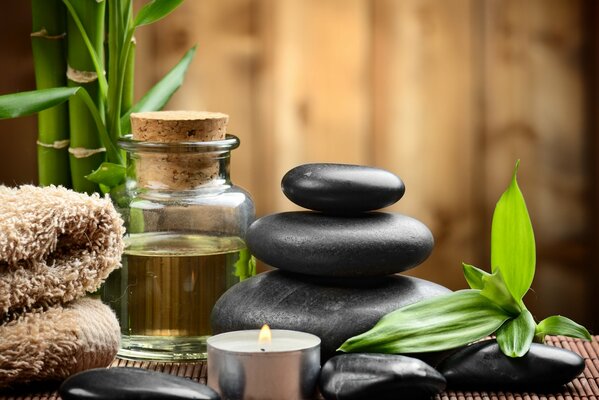 There are stones, candles and oil on the table in the spa