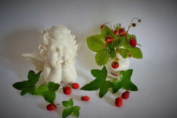 Still life of an angel figurine and strawberries