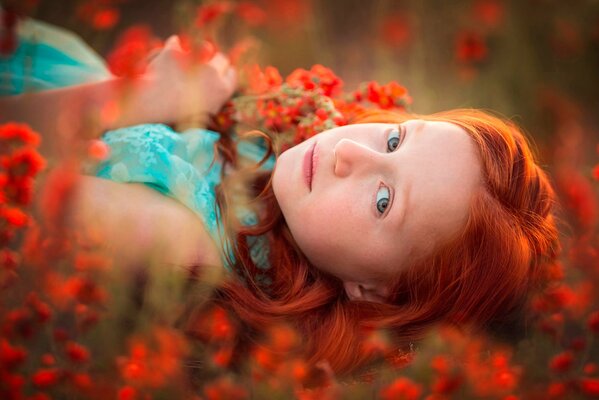 Ragazza dai Capelli rossi sulla radura con i fiori